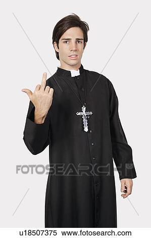 Portrait of young man in priest costume with rude gesture against gray background View Large Photo Image Stock Photography - Portrait of young man in priest costume with rude gesture against gray background. Fotosearch
