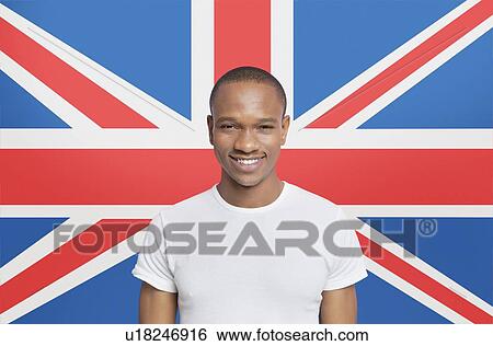 Portrait of young man in white t-shirt smiling against British flag View Large Photo Image Stock Photograph - Portrait of young man in white t-shirt smiling against British flag. Fotosearch