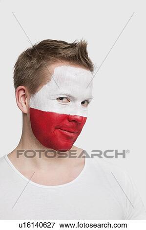 Stock Photo - Portrait of young man with Polish flag painted on face smiling against white background. Fotosearch