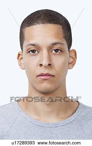 Stock Image - Portrait of young mixed race man against white background. Fotosearch