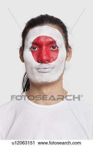 Stock Image - Portrait of young mixed race man with Japanese flag painted on face against white background. Fotosearch