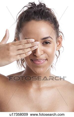 Portrait of young Mixed Race woman covering her eye with hand against white background View Large Photo Image Stock Photo - Portrait of young Mixed Race woman covering her eye with hand against white background. Fotosearch