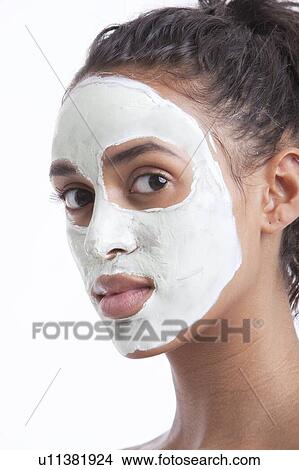 Portrait of young Mixed Race woman with face pack against white background View Large Photo Image Picture - Portrait of young Mixed Race woman with face pack against white background. Fotosearch
