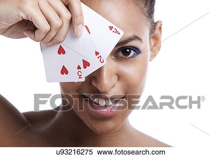 Portrait of young Mixed Race woman with playing cards biting her lip against white background View Large Photo Image Stock Photography - Portrait of young Mixed Race woman with playing cards biting her lip against white background. Fotosearch