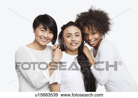 Portrait of young multi-ethnic female friends smiling over white background View Large Photo Image Stock Photo - Portrait of young multi-ethnic female friends smiling over white background. Fotosearch