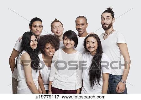 Stock Photo - Portrait of young multi-ethnic friends smiling together against white background. Fotosearch