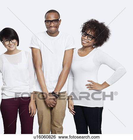 Stock Photograph - Portrait of young multi-ethnic friends in casuals smiling together over white background. Fotosearch