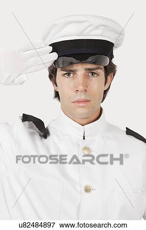 Portrait of young navy officer saluting against gray background View Large Photo Image Stock Photo - Portrait of young navy officer saluting against gray background. Fotosearch
