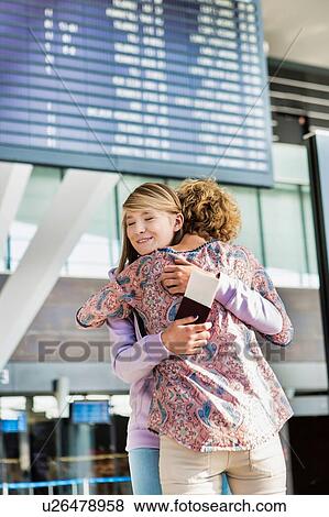 Stock Photo - Portrait of young teenage girl reunting with her mother in airport. Fotosearch
