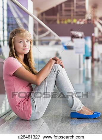 Portrait of young teenage girl sitting on the floor in airport View Large Photo Image Stock Photo - Portrait of young teenage girl sitting on the floor in airport. Fotosearch