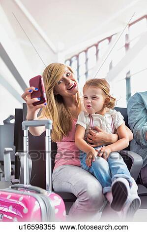 Portrait of young teenage girl taking selfie with her little sister while waiting for boarding in airport View Large Photo Image Stock Photography - Portrait of young teenage girl taking selfie with her little sister while waiting for boarding in airport. Fotosearch