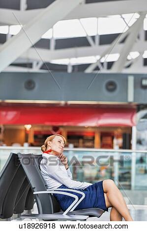 Stock Photo - Portrait of young thoughtful attractive airport staff sitting during break. Fotosearch