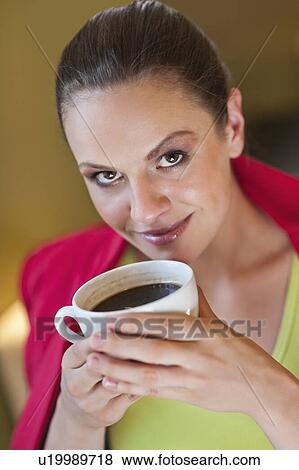Portrait of young woman holding coffee cup View Large Photo Image Stock Photo - Portrait of young woman holding coffee cup. Fotosearch