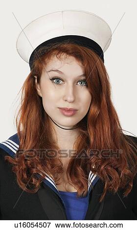 Stock Photo - Portrait of young woman in sailor's uniform against gray background. Fotosearch