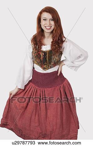 Portrait of young woman in old-fashioned costume standing against gray background View Large Photo Image Stock Image - Portrait of young woman in old-fashioned costume standing against gray background. Fotosearch