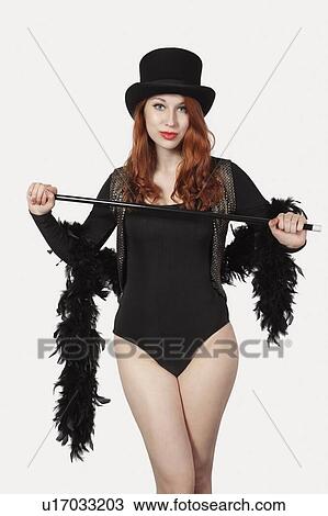 Stock Image - Portrait of young woman old fashioned magician costume looking away against gray background. Fotosearch