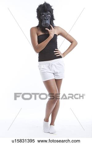 Portrait of young woman wearing gorilla mask with hand on hips against white background View Large Photo Image Stock Photography - Portrait of young woman wearing gorilla mask with hand on hips against white background. Fotosearch