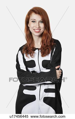 Portrait of young woman with arms crossed in skeleton costume against gray background View Large Photo Image Stock Photography - Portrait of young woman with arms crossed in skeleton costume against gray background. Fotosearch