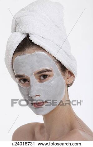 Portrait of young woman with face pack and towel wrapped around head against white background View Large Photo Image Stock Image - Portrait of young woman with face pack and towel wrapped around head against white background. Fotosearch