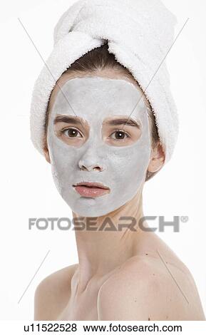 Portrait of young woman with face pack and towel wrapped around head against white background View Large Photo Image Stock Photo - Portrait of young woman with face pack and towel wrapped around head against white background. Fotosearch