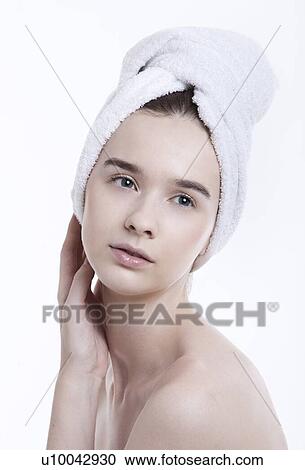 Portrait of young woman with towel wrapped around her head against white background View Large Photo Image Stock Image - Portrait of young woman with towel wrapped around her head against white background. Fotosearch