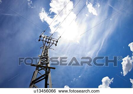 Power lines against blue sky and sun View Large Photo Image Stock Photograph - Power lines against blue sky and sun. Fotosearch