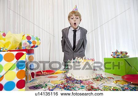 Pre-teen birthday boy blowing candles on cake View Large Photo Image Stock Photograph - Pre-teen birthday boy blowing candles on cake. Fotosearch