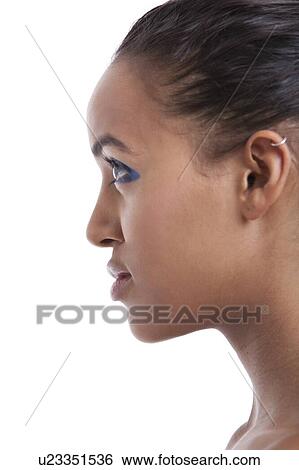Stock Photograph - Profile shot of beautiful young woman with blue eyeshadow against white background. Fotosearch