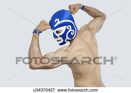 Rear view of a shirtless man in wrestling mask flexing muscles over gray background View Large Photo Image Stock Photo - Rear view of a shirtless man in wrestling mask flexing muscles over gray background. Fotosearch