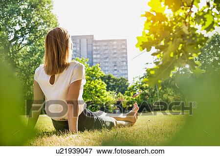Rear view of young attractive businesswoman sitting on the grass while watching the sunset View Large Photo Image Stock Photo - Rear view of young attractive businesswoman sitting on the grass while watching the sunset. Fotosearch