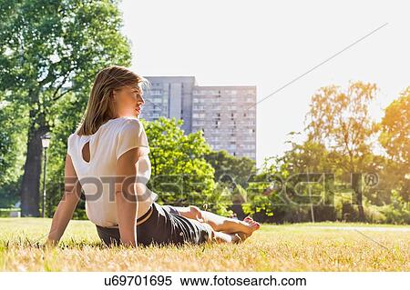 Rear view of young attractive businesswoman sitting on the grass while watching the sunset View Large Photo Image Stock Photography - Rear view of young attractive businesswoman sitting on the grass while watching the sunset. Fotosearch