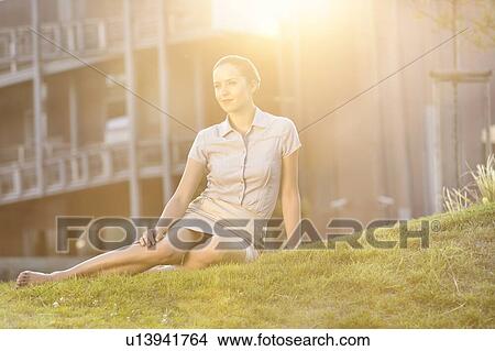 Relaxed young businesswoman sitting on office lawn View Large Photo Image Picture - Relaxed young businesswoman sitting on office lawn. Fotosearch