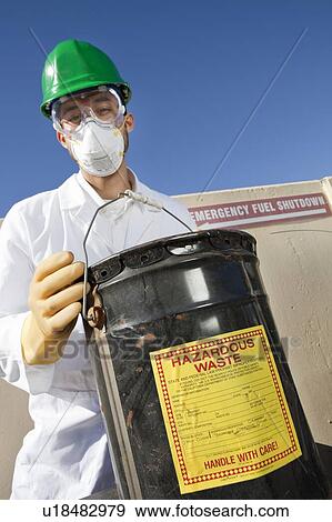 Safety inspector holding hazardous waste View Large Photo Image Stock Photo - Safety inspector holding hazardous waste. Fotosearch