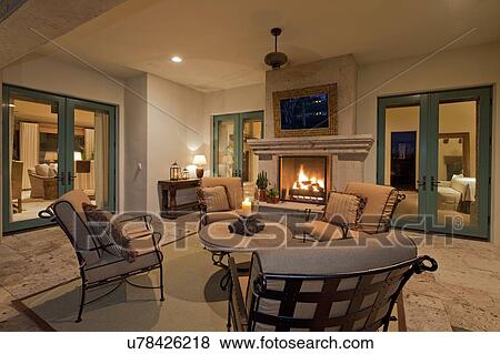 Stock Photo - Seating furniture near fireplace in living room of villa. Fotosearch