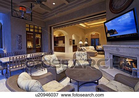Stock Photo - Seating furniture near fireplace with television in room of luxury villa. Fotosearch
