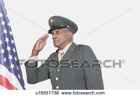 Stock Photo - Senior male US military officer saluting American flag over gray background. Fotosearch