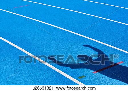 Stock Image - Shadow of an athlete celebrating success in finish line . Fotosearch