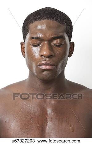 Stock Image - Shirtless young African American man sweating over white background. Fotosearch