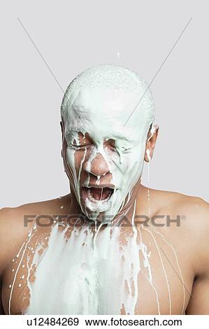 Shirtless young man covered in paint with mouth open against gray background View Large Photo Image Stock Photo - Shirtless young man covered in paint with mouth open against gray background. Fotosearch