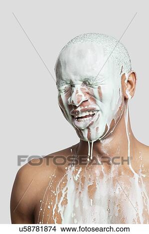Shirtless young man with face covered in paint against gray background View Large Photo Image Picture - Shirtless young man with face covered in paint against gray background. Fotosearch