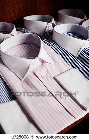 Stock Photography - Shirts on shelves in tailor shop. Fotosearch