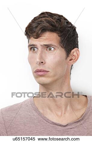 Shocked young man looking away against white background View Large Photo Image Stock Photography - Shocked young man looking away against white background. Fotosearch