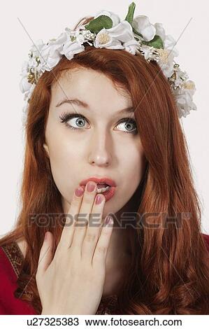 Stock Image - Shocked young woman in old-fashioned princess costume looking away against gray background. Fotosearch