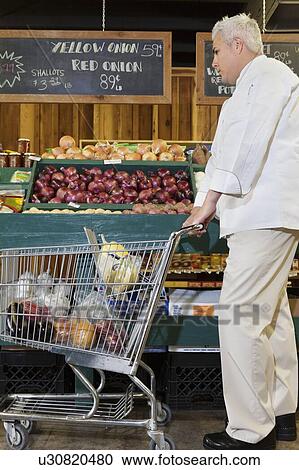 Side view of mid adult chef with shopping cart in market View Large Photo Image Stock Image - Side view of mid adult chef with shopping cart in market. Fotosearch