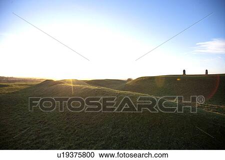 Stock Image - Sun flare over Hill of Tara, Ireland. Fotosearch