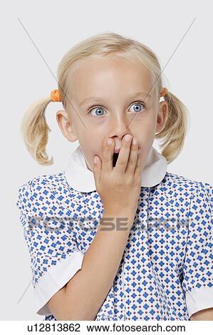 Surprised young girl covering mouth with her hand over white background View Large Photo Image Stock Image - Surprised young girl covering mouth with her hand over white background. Fotosearch
