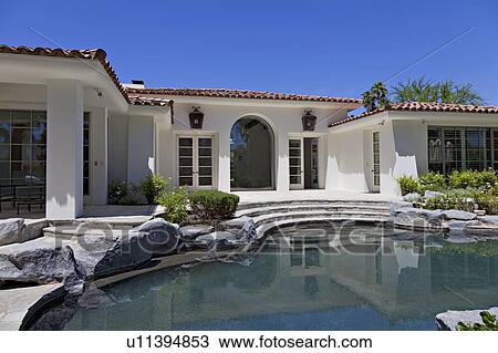 Stock Image - Swimming pool in front of luxury villa. Fotosearch