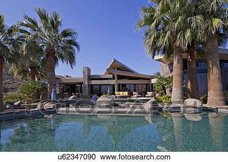 Stock Image - Swimming pool in front of manor house. Fotosearch