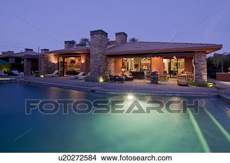 Swimming pool with patio under lights of luxury mansion View Large Photo Image Picture - Swimming pool with patio under lights of luxury mansion. Fotosearch