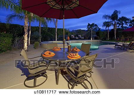 Table and chair under sunshade at poolside in manor house View Large Photo Image Stock Photo - Table and chair under sunshade at poolside in manor house. Fotosearch